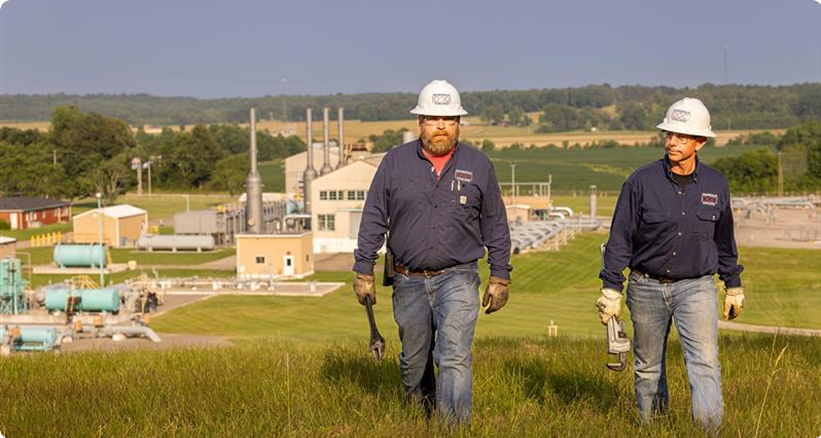 Boardwalk field technicians walking near a compressor station